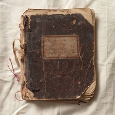 an old book sitting on top of a white sheet