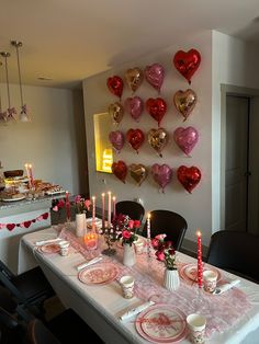 a table set for valentine's day with candles and plates