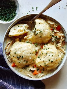 a bowl filled with chicken and dumplings on top of a table