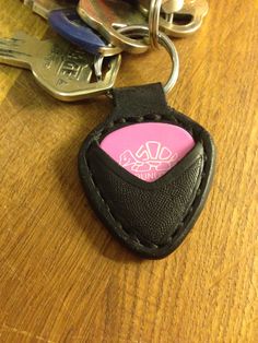 a leather key chain with a pink and black case