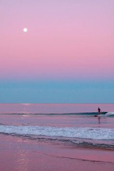 a person riding a wave on top of a surfboard in the ocean at sunset