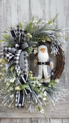 a christmas wreath with a stuffed santa claus on it