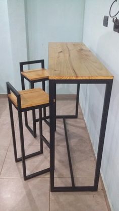 three wooden chairs sitting next to each other on top of a tile floor in front of a white wall