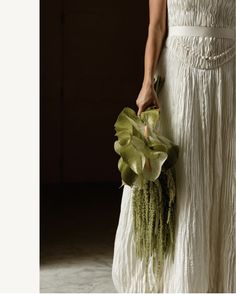 a woman in a white dress holding a bouquet