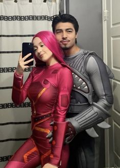 the man and woman are dressed up as cosplays, one is taking a selfie