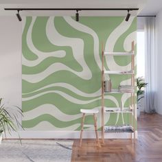 a room with a book shelf, plant and wallpaper on the walls that has an abstract pattern