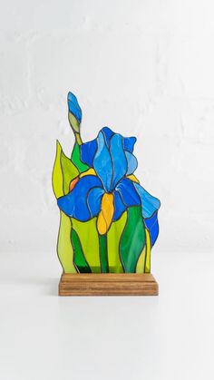 a stained glass blue flower on a wooden stand