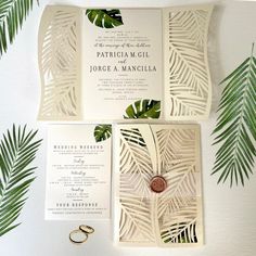 the wedding stationery is made from laser cut paper and features tropical leaves on it