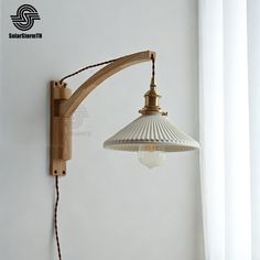 an old fashioned wall light hanging on the side of a white wall in a room