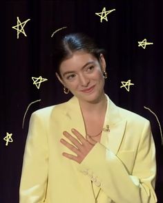 a woman standing in front of a black curtain with stars on it's wall