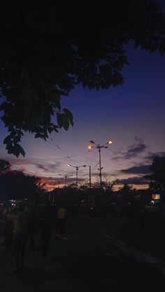 some people are walking down the street at night with their backs turned to the camera