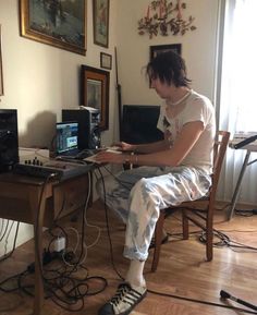 a man sitting at a desk with a laptop computer on top of it and wires in front of him