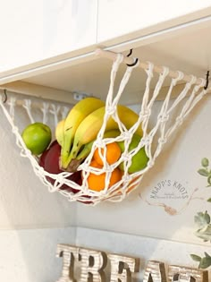 there are bananas, oranges and apples in a basket on the kitchen wall shelf