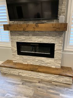 a television mounted on top of a brick fireplace