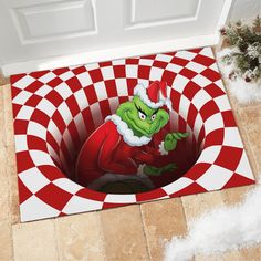 the grin face is peeking out from behind a red and white checkered door mat