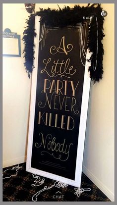 a little party never killed nobody chalkboard sign with black feathers and gold foil lettering