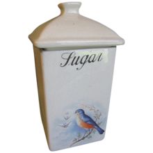 a white ceramic container with a bird painted on it's side and the word lingan written in black