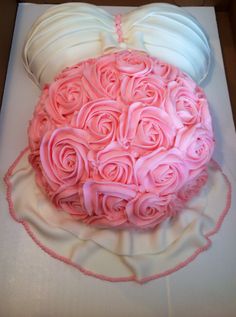 the cake is decorated with pink roses and white frosting