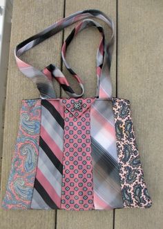 a bag with ties on it sitting on the ground next to a purse that is made out of fabric