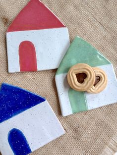 two ceramic plates with small houses and a doughnut on them, sitting on a table