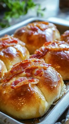 three hot dogs in a pan with bacon on top, ready to be baked into buns