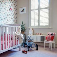 a baby's room with pink and white decor, including an owl crib