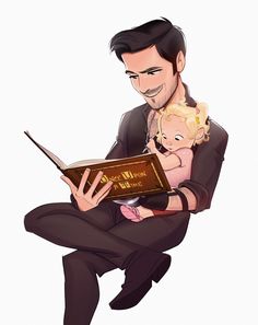 a man holding a baby while reading a book