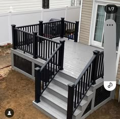 a deck with black railing and white steps