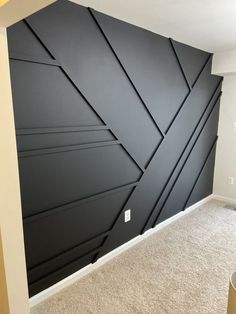 an empty room with black painted walls and carpeted flooring in the foreground