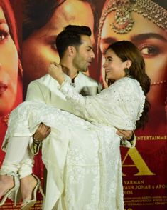 a man and woman hugging each other in front of a poster for the movie aaad