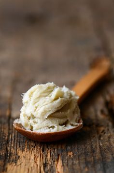 a wooden spoon filled with mashed potatoes on top of a table