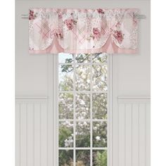 a window with a pink flowered valance hanging over it