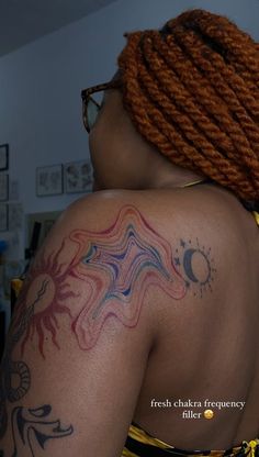 the back of a woman's shoulder with tattoos on her left arm and chest