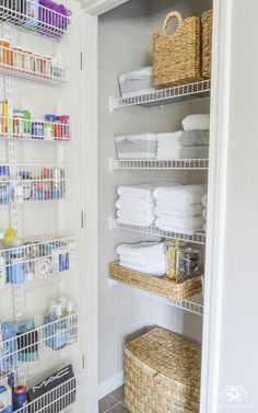 an organized pantry with baskets and towels