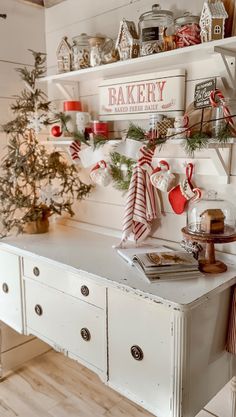 a white table topped with christmas decorations next to a shelf filled with candy canes