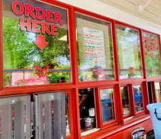 there is a red store front with many signs on the windows and in the window