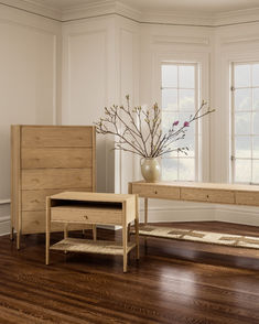 a living room with wooden floors and white walls, including a coffee table and two end tables