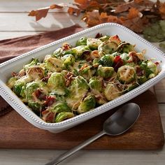 a white casserole dish filled with brussel sprouts and bacon