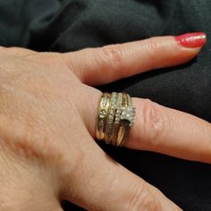 a woman's hand with three different rings on her finger and one ring in the middle