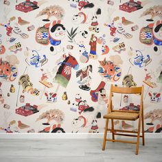 a wooden chair sitting in front of a wall covered with cartoon characters and cats on it