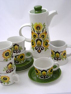 a tea set with sunflowers painted on it