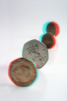 some coins are laying on top of each other in the middle of a white surface