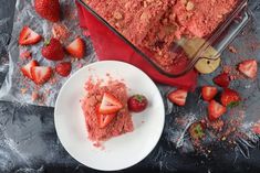 there is a piece of cake with strawberries on the plate next to it and some other food