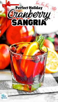 the perfect holiday cranberry sangria is served in a glass with orange slices and rosemary garnish