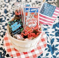 a basket filled with snacks on top of a checkered table cloth