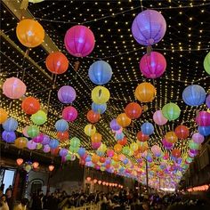 many colorful lanterns are hanging from the ceiling