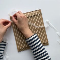 someone is wrapping something up on a mat with twine and ribbon around it to make an ornament