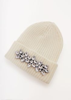 a white beanie with crystal brooches on it