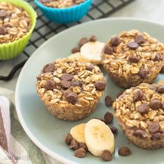 three banana chocolate chip muffins on a plate next to two cupcake tins