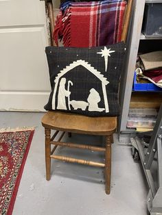 a christmas scene pillow sitting on top of a wooden chair